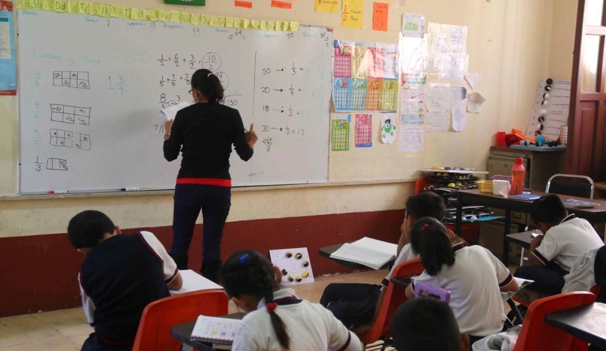 Maestra y alumnos en salón de clases