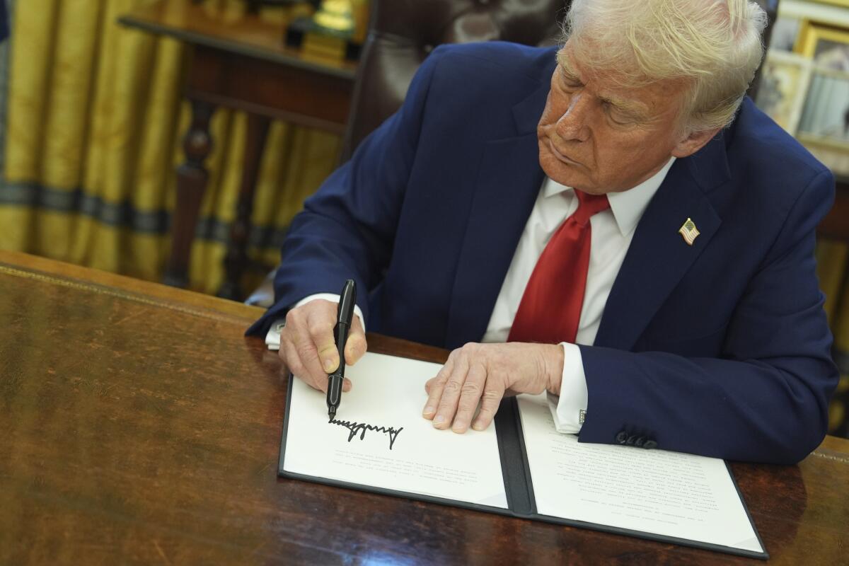 Trump firmando documentos