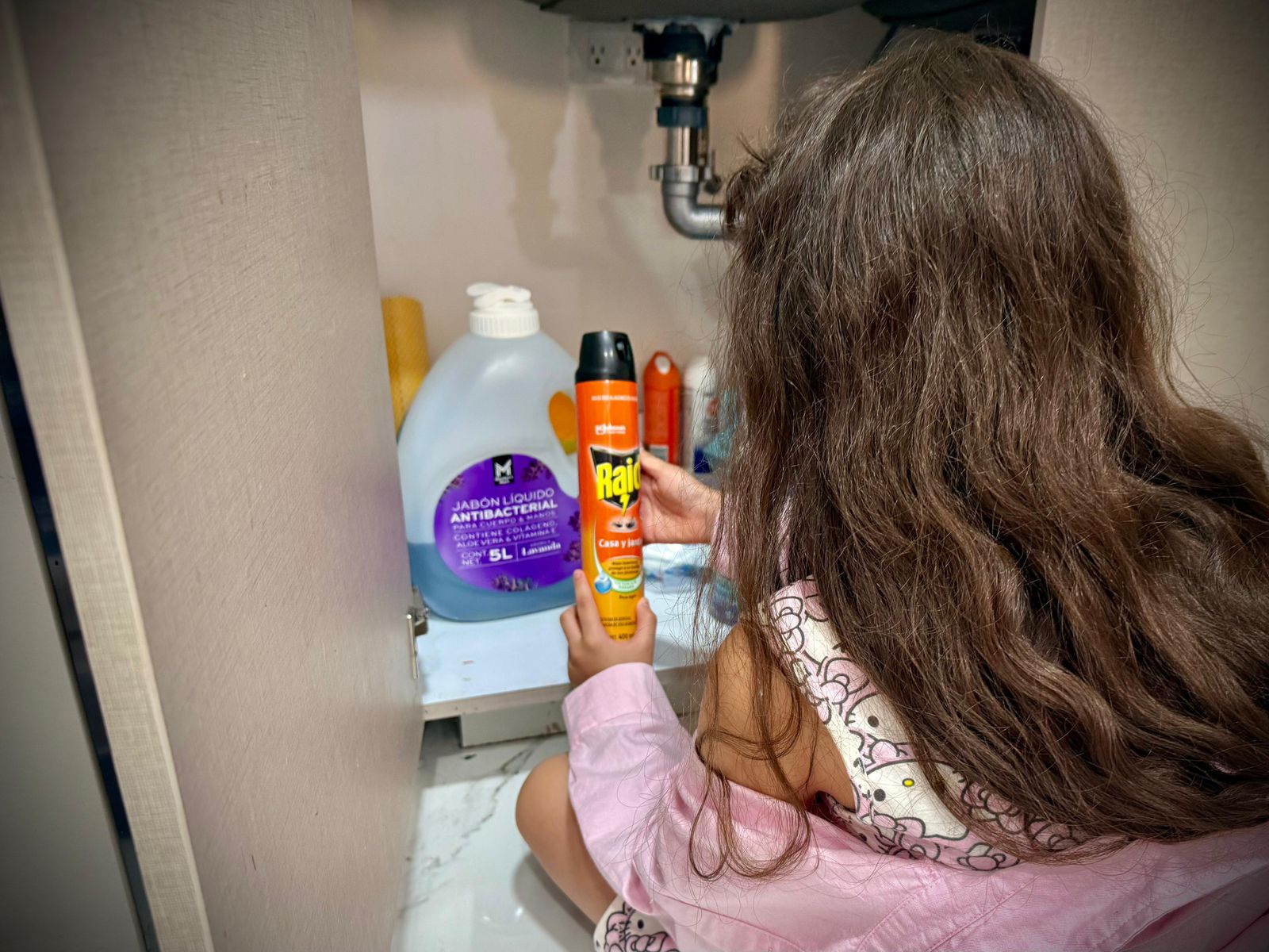 niña manipulando insecticida