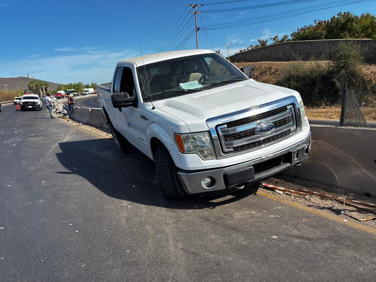 Camioneta Ford Lobo de color blanco arriba del muro de contención