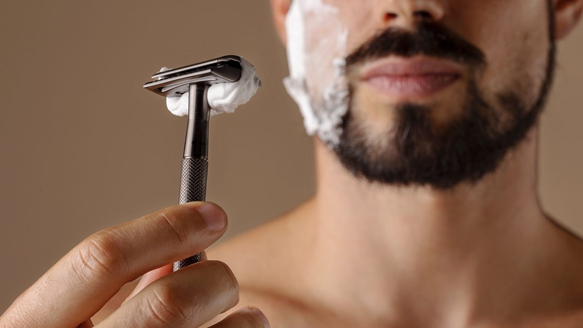 Hombre afeitándose con rastrillo