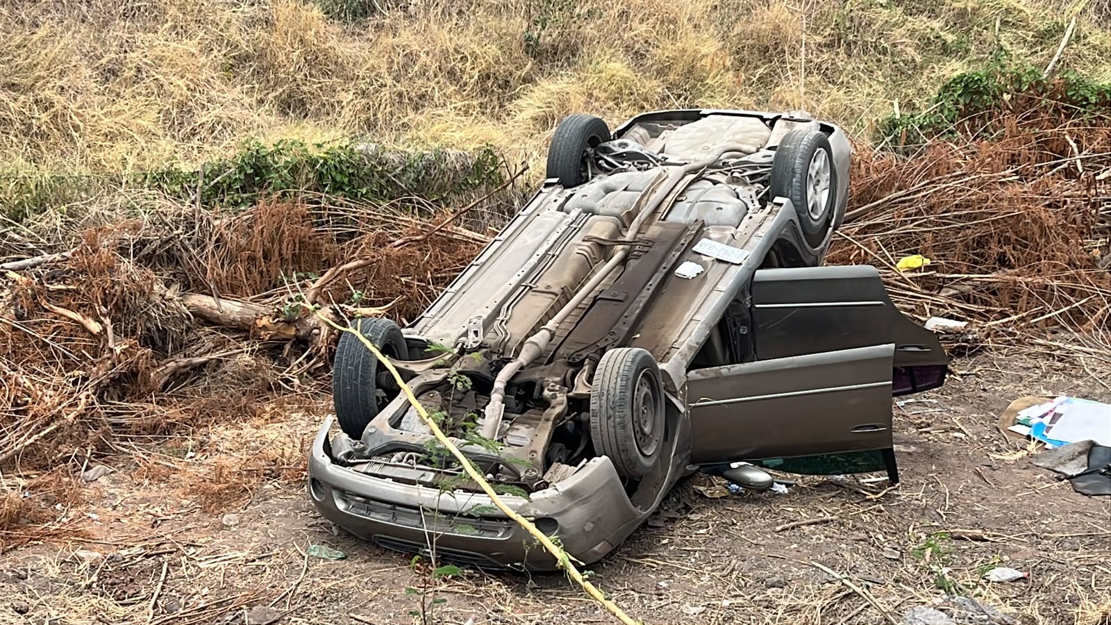automóvil Nissan Sentra volcado llantas arriba