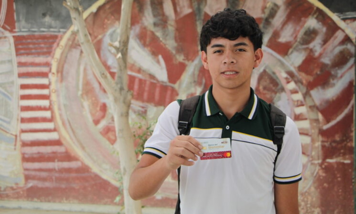 Joven beneficiario de la Beca Benito Juárez con su tarjeta del Bienestar