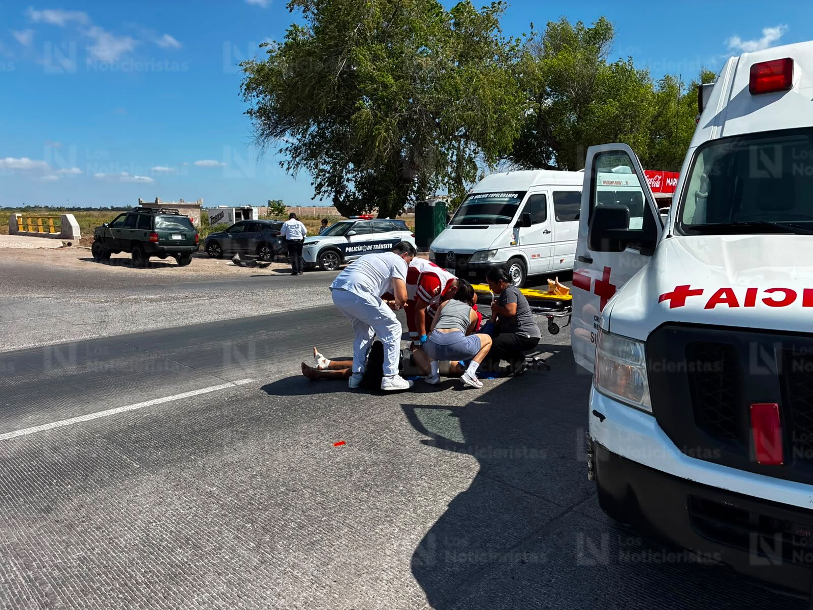 Paramédico de Cruz Roja atendiendo a motociclista arrollado