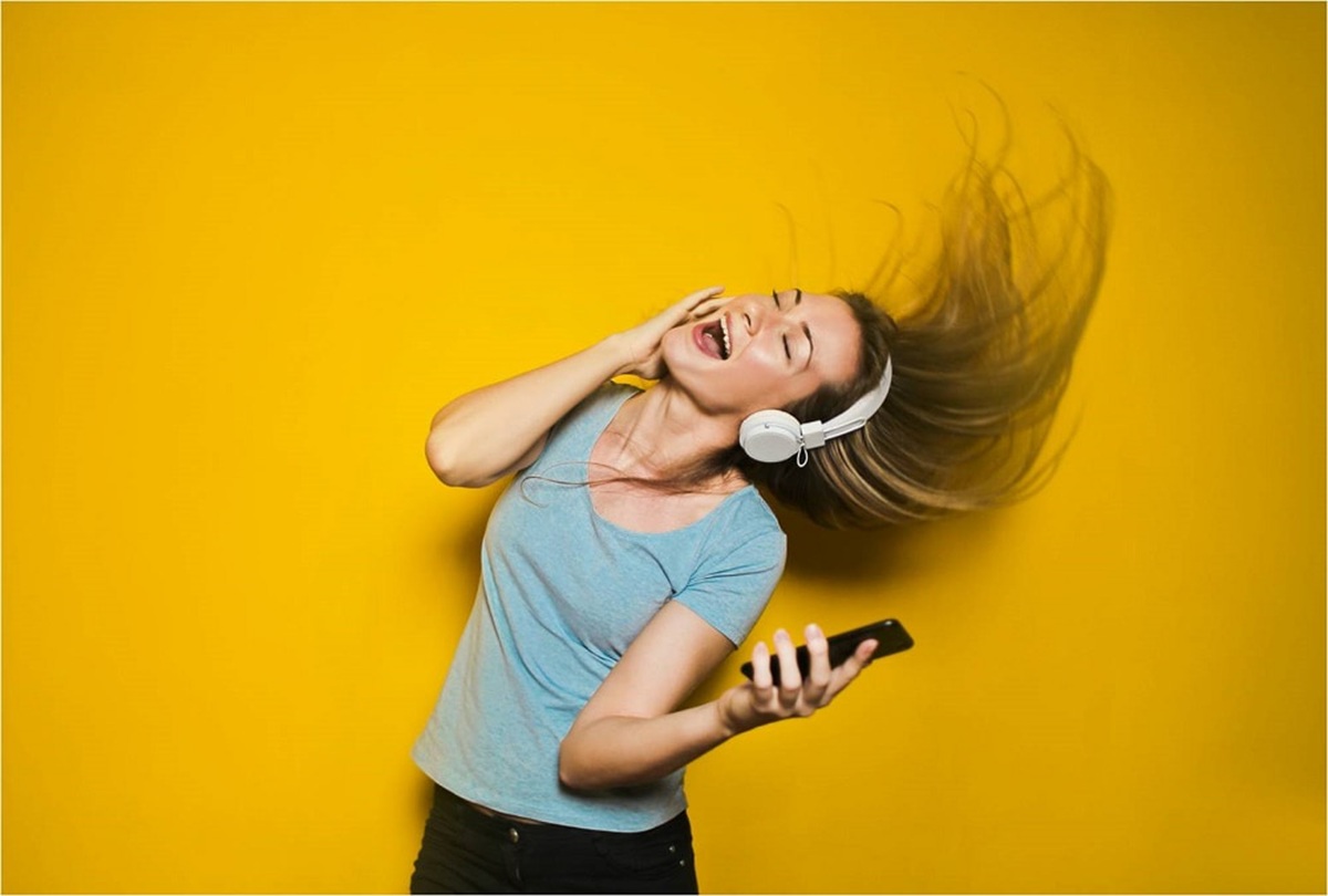 Joven mujer escuchando con audífonos a todo volumen
