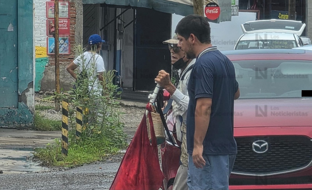 Joven para el tráfico para ayudar a adulto mayor invidente a cruzar vialidad