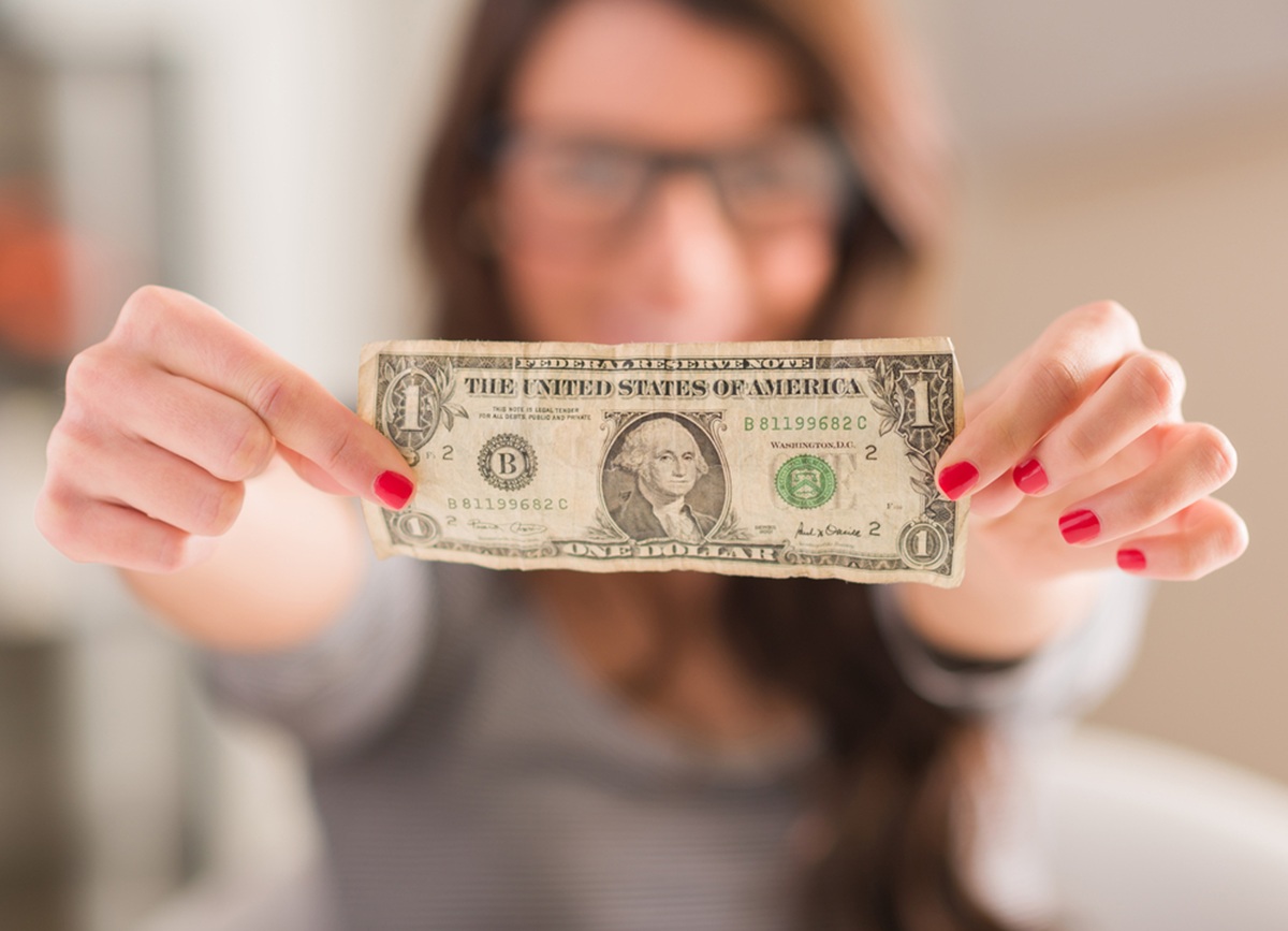 Joven mujer con billete de dólar