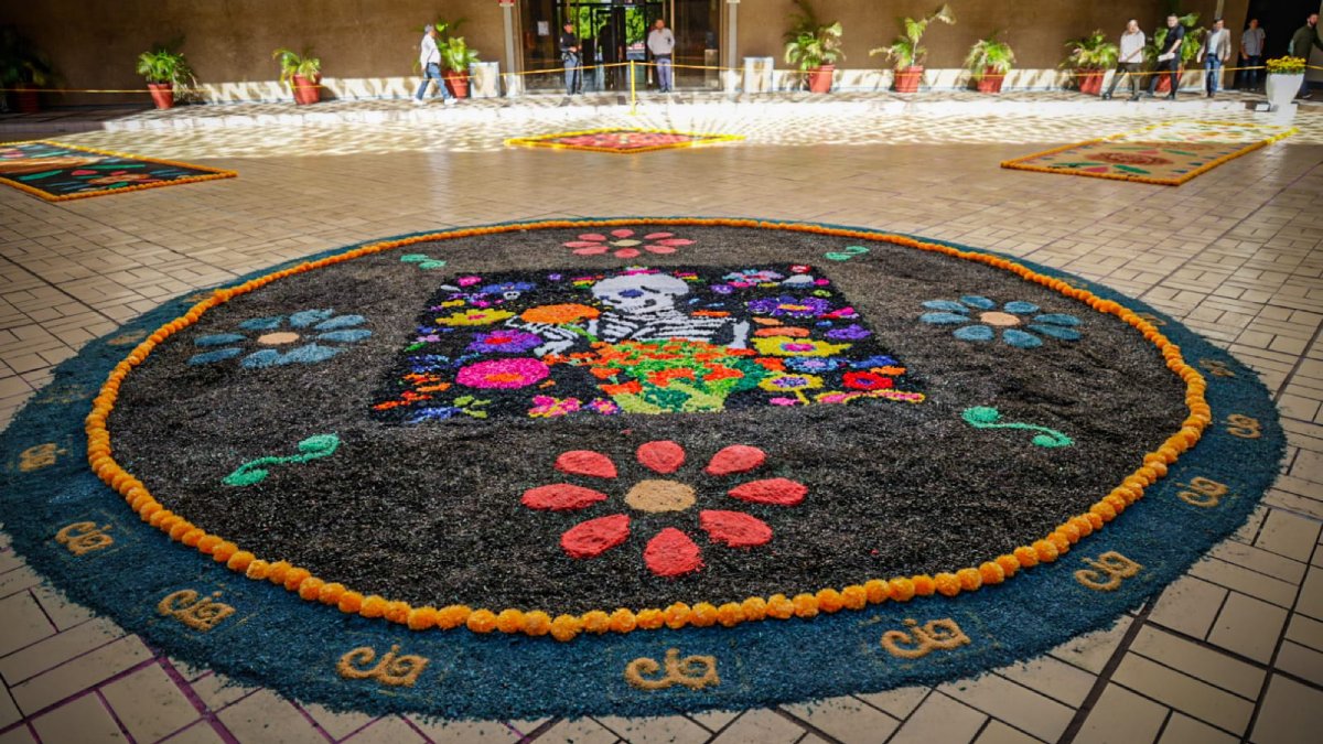reconoce graciela dominguez a participantes en la elaboracion de ofrenda de dia de muertos tapete